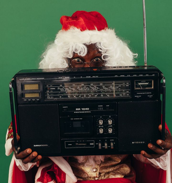 Père Noël tenant une radio vintage